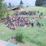 nepalese people sit on grass terrain