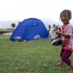 nepalese girl smiles hold sleeping bag