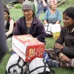 two nepalese woman smile at box food