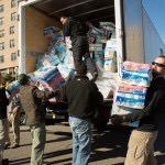 men unload toilet paper off truck