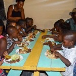 haitian children eat on table
