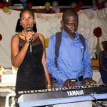 haitian man plays keyboard and woman singing